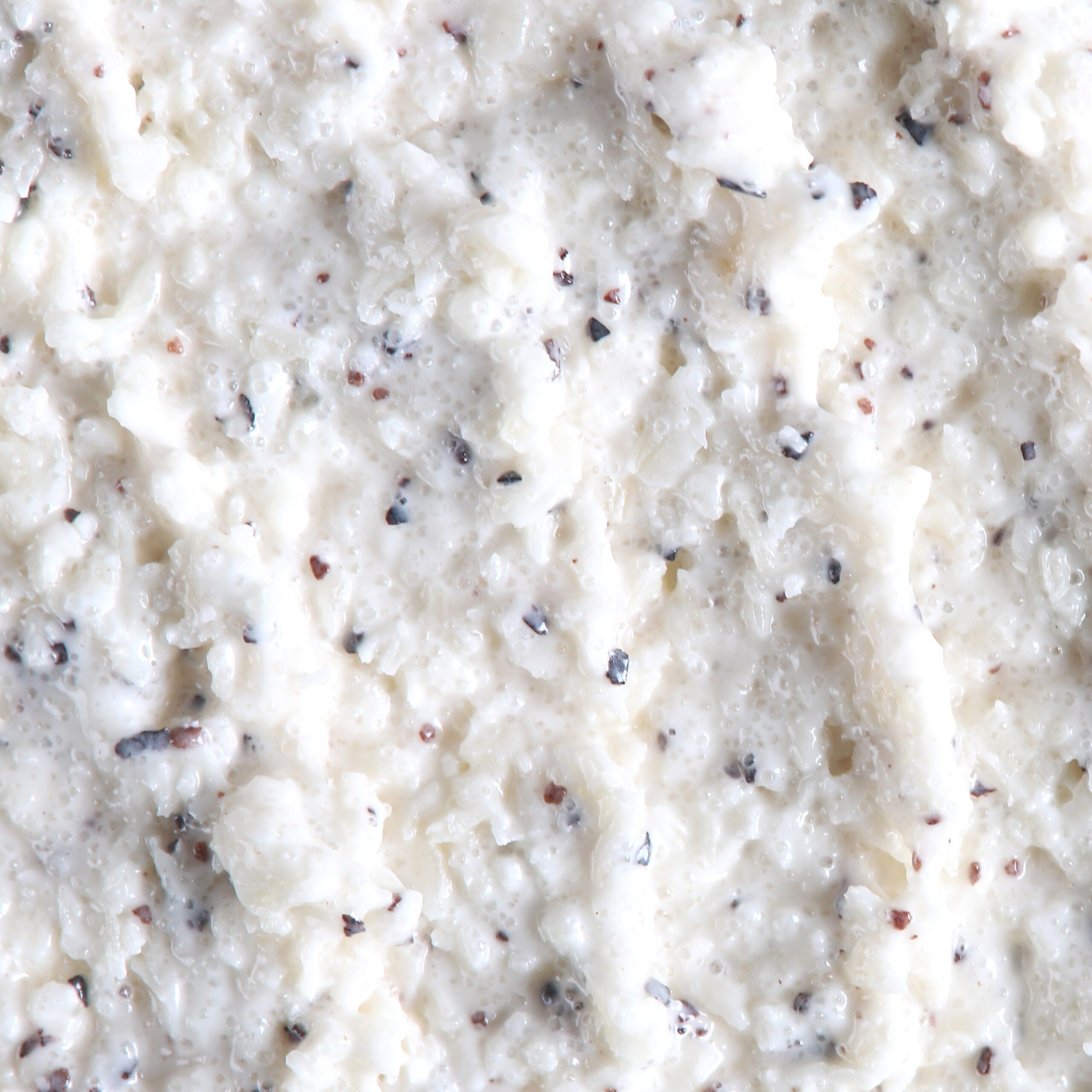 Granita body scrub texture with coconut, sea salt, and plant-based exfoliants.